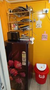 Un pequeño refrigerador en una habitación con flores. en The Pali Den A Whisper of Pali Village, Bandra, en Bombay