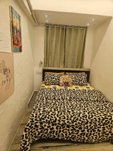 Un dormitorio con una cama con estampado de leopardo y una ventana en The Pali Den A Whisper of Pali Village, Bandra, en Bombay