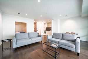 a living room with two couches and a table at Princes Wharf - Spectacular Couple Getaway in Auckland