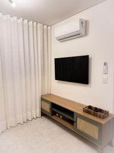 a living room with a flat screen tv on a wall at Refugio a 50 passos do mar in Tamandaré