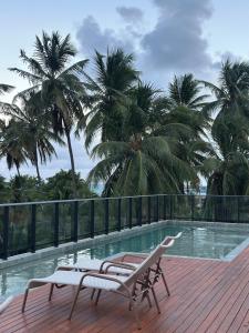 a deck with two lounge chairs and a swimming pool at Refugio a 50 passos do mar in Tamandaré