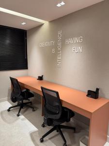 an office cubicle with a desk and two chairs at Refugio a 50 passos do mar in Tamandaré +12 photos