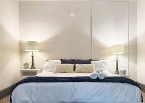 a bedroom with a large white bed with two pillows at Suite Home Indiana Apartments in Evansville