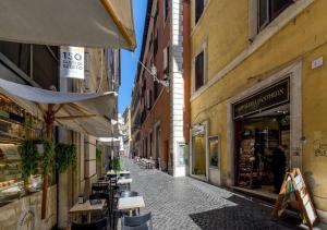 un callejón con mesas y sombrillas en una calle de la ciudad en Vittoriano Pantheon apartment, en Roma