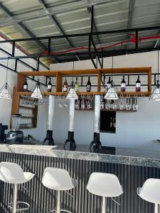 eine Bar mit weißen Tischen und weißen Stühlen in der Unterkunft Shukran Habibi Resort in Santa Rita