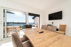 a dining room with a wooden table and a view of the ocean at Seaview Villa Summer with private pool & garden in Rtina