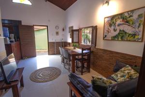 a living room with a table and a dining room at Casinha Canoa - Casa Com Ar-Condicionados e Localização Perfeita in Canoa Quebrada