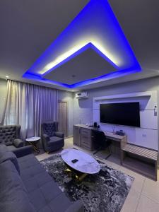 a living room with a couch and a blue ceiling at Grand Riviera Hotel in Port Harcourt