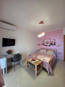 a bedroom with a bed and a table and a desk at B&B Angelina in Minturno