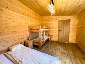 a bedroom with two bunk beds in a wooden cabin at Dom całoroczny in Kowal