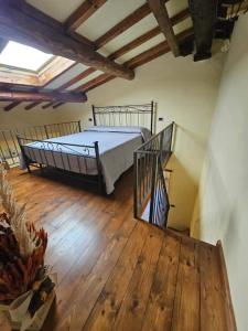 a bedroom with a bed and a wooden floor at Casa del Podestà - Montopoli Val d'Arno in Montopoli in Val dʼArno