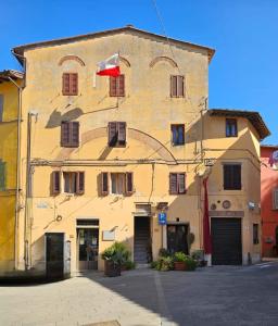 a large yellow building with a flag on it at Casa del Podestà - Montopoli Val d'Arno in Montopoli in Val dʼArno