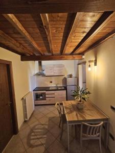 a kitchen with a wooden table and a table and chairs at Casa del Podestà - Montopoli Val d'Arno in Montopoli in Val dʼArno