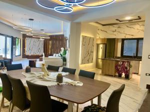 a dining room with a wooden table and chairs at TheIcon Boutique Villa Next to The Largest Museum in the World the Egyptian Grand museum in Sheikh Zayed