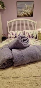 ein Bett mit einer lila Decke darauf in der Unterkunft Taff Cottage - Free parking, Fast Wifi, Cosy vibe in Cardiff