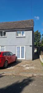 ein rotes Auto, das vor einem Haus parkt in der Unterkunft Taff Cottage - Free parking, Fast Wifi, Cosy vibe in Cardiff