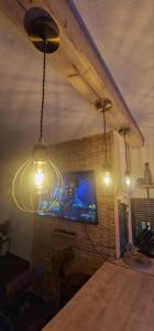 eine Gruppe von Lichtern, die in einem Raum mit einem Fernseher hängen in der Unterkunft Taff Cottage - Free parking, Fast Wifi, Cosy vibe in Cardiff