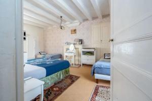 a bedroom with two beds and a desk and a fireplace at La clé des jardins in Nouâtre