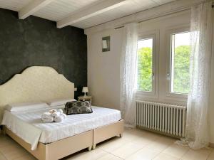 a bedroom with a bed and a large window at Locanda Divinis in Cerea
