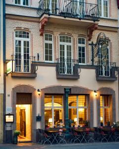 a hotel with tables and chairs in front of a building at Nostalgie Altstadthotel Kornpforte in Koblenz