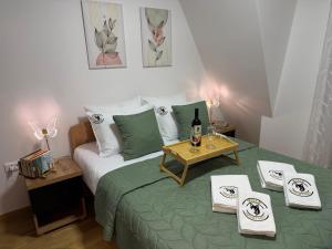 a bedroom with a bed and a table with a bottle of wine at WOLF apartman in Divčibare