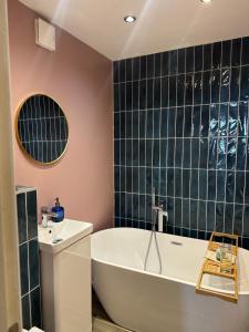 a bathroom with a tub and a sink at Beautiful Mews house just off Marylebone High St in London