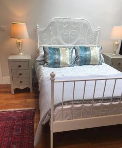 a bedroom with a white bed with pillows on it at Beautiful Mews house just off Marylebone High St in London
