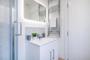 une salle de bain blanche avec un lavabo et un miroir dans l'établissement The Weaver by Nesting Hub, à Newcastle-under-Lyme 26 autres photos