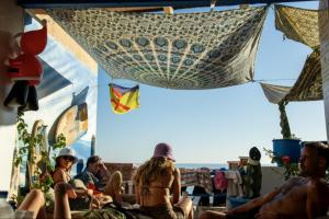 a group of people sitting on the beach at Hostel The Endless House Anchor point in Taghazout
