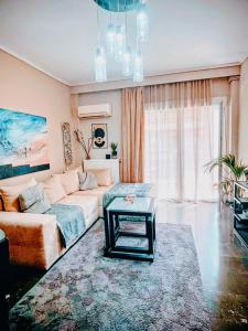 塞萨洛尼基Mitropolews 55 apartment的客厅里有一张沙发和一张桌子。