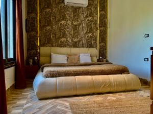 a bedroom with a bed with a large headboard at TheIcon Boutique Villa Next to The Largest Museum in the World the Egyptian Grand museum in Sheikh Zayed