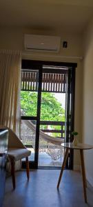 a living room with a door open to a balcony at Casa Californiana Pousada in Garopaba