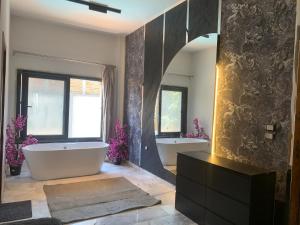 a bathroom with two sinks and a tub and a mirror at TheIcon Boutique Villa Next to The Largest Museum in the World the Egyptian Grand museum in Sheikh Zayed +16 photos