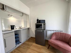 a small kitchen with a chair and a microwave at Bienvenue à L'Oustalet - Studio 3 in Cazaubon