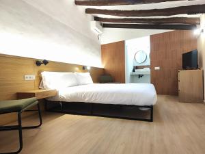 a hotel room with a large bed and a tv at Mazi Plaça Gran in Mataró