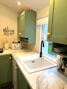 a kitchen with green cabinets and a sink at Spacious Apartment in Central Edinburgh in Edinburgh