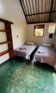 a room with two beds and a window at Chalé Único in Alto Paraíso de Goiás