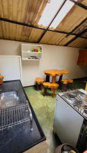a kitchen with a stove and a sink and a table at Chalé Único in Alto Paraíso de Goiás +21 photos
