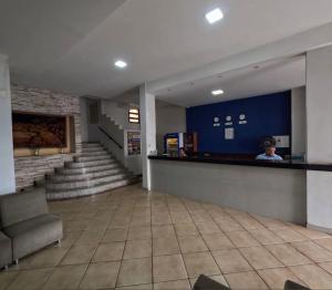 eine Lobby mit einer Person, die an einer Theke steht in der Unterkunft Novo Mundo Hotel in Barra do Garças