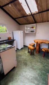 a kitchen with a table and a refrigerator and a table at Chalé Único in Alto Paraíso de Goiás