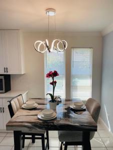 a dining room with a table with a flower on it at Stunning Home in Plano! in Plano +5 photos