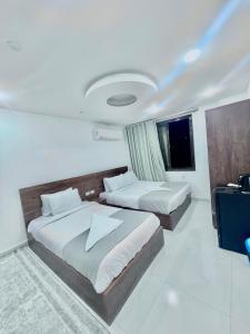 a hotel room with two beds and a television at &pyramids &Prince &view2 in Cairo