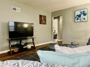 a living room with two couches and a flat screen tv at Central Chic on Washington in Evansville
