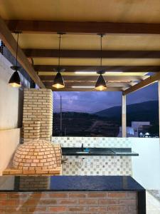 eine Terrasse mit einer Bank und einem Fenster mit Aussicht in der Unterkunft Refúgio do Mel - Piscina e Forno a Lenha in Gravatá