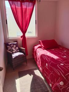 a bedroom with a red bed and a window at Dpto Bordemar 1 in Las Cruces