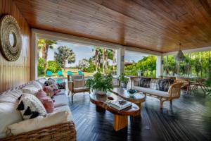 Una sala de estar llena de muebles y una gran ventana. en Deluxe 5BR Villa Overlooking Golf, en El Caletón
