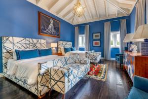 Un dormitorio con paredes azules y una cama y un sofá. en Deluxe 5BR Villa Overlooking Golf, en El Caletón 24 fotos más