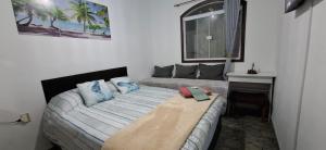 une chambre avec un lit, un bureau et une fenêtre dans l'établissement Brachil 1, à Búzios