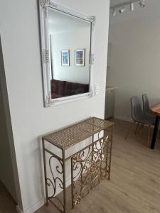 a mirror on a wall next to a table at Premium Apartament Koronowska 40m2 in Bydgoszcz