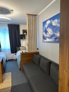 a living room with a couch and a bedroom at Riverside Apartmani Kopaonik in Brzeće